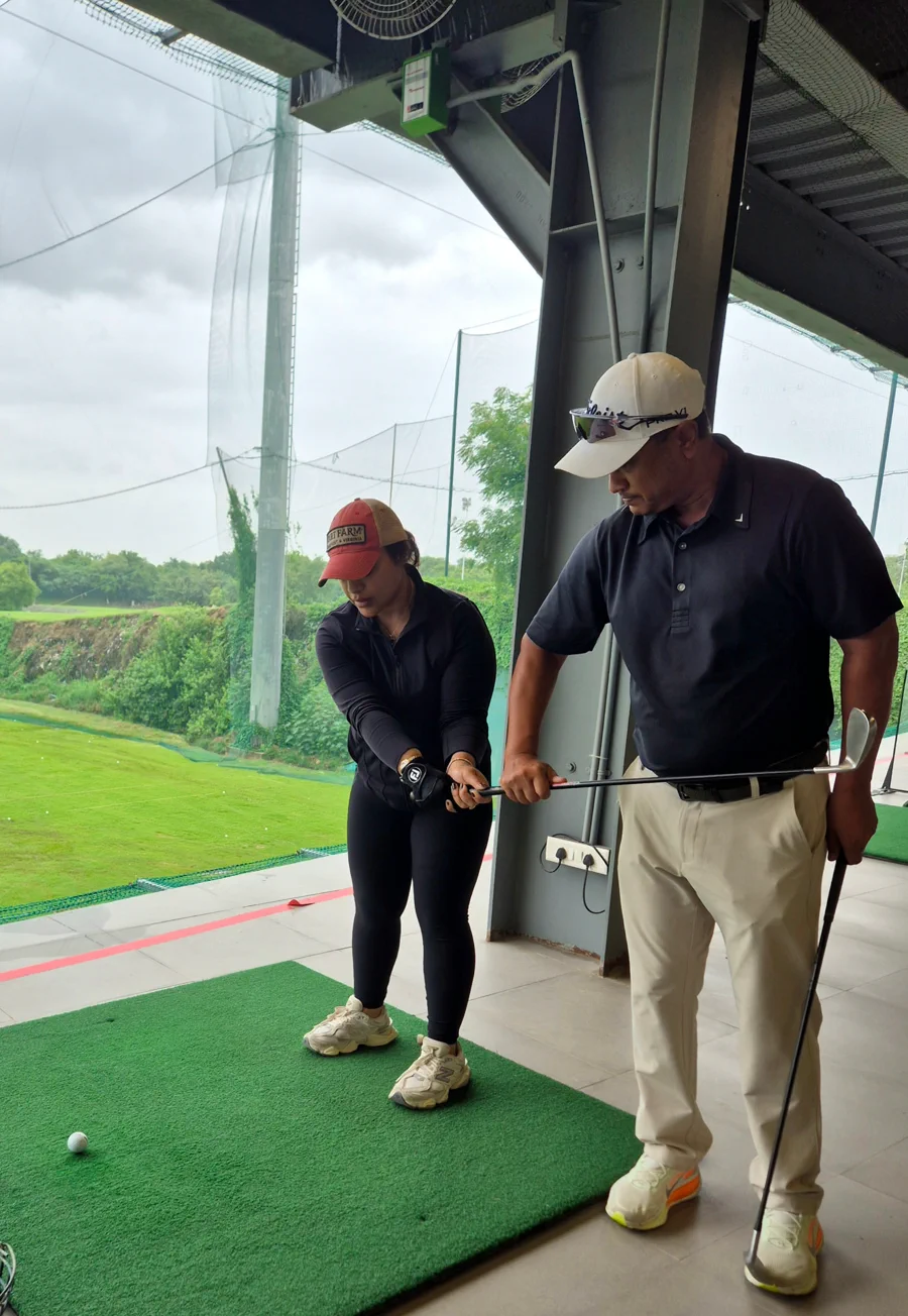 Coach Amit Khaitan correcting an adult student's grip during a lesson